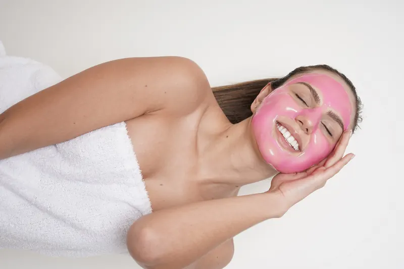 Femeie relaxată cu mască roz esthemax® Hydrojelly® pe față